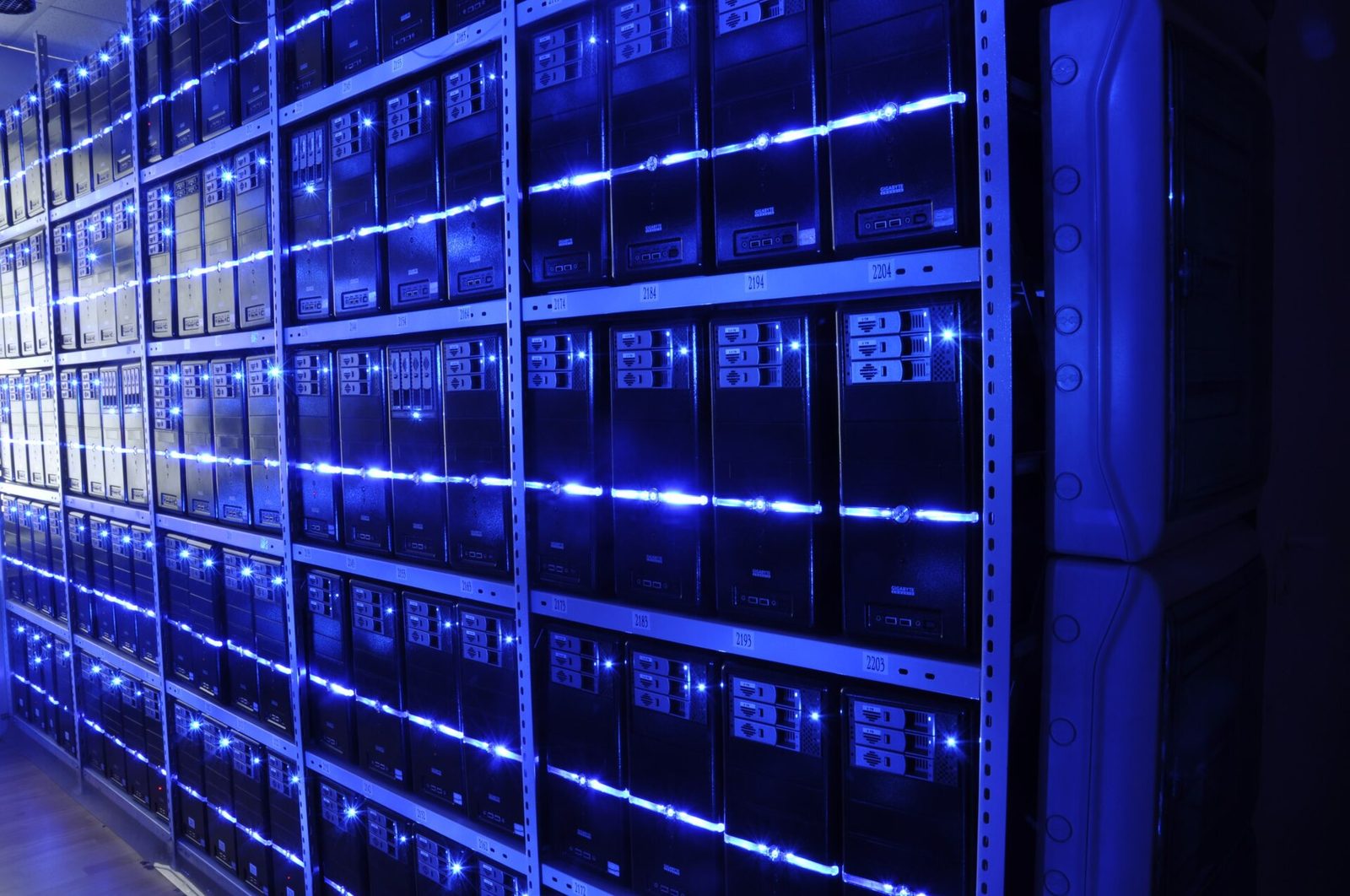 Rows of server racks in a data center lit with blue light
